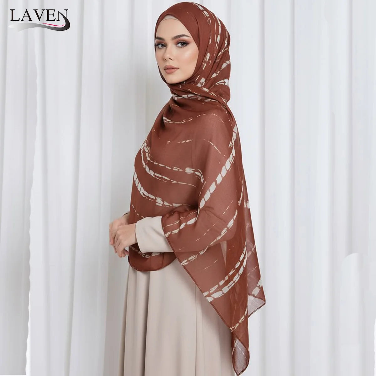 A woman wearing a brown watercolor print modal scarf and a beige dress, photographed in a studio setting.