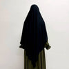 Eine Frau trägt einen schwarzen, atmungsaktiven Bambus-Jersey-Khimar-Hijab über ein grünes Kleidungsstück.