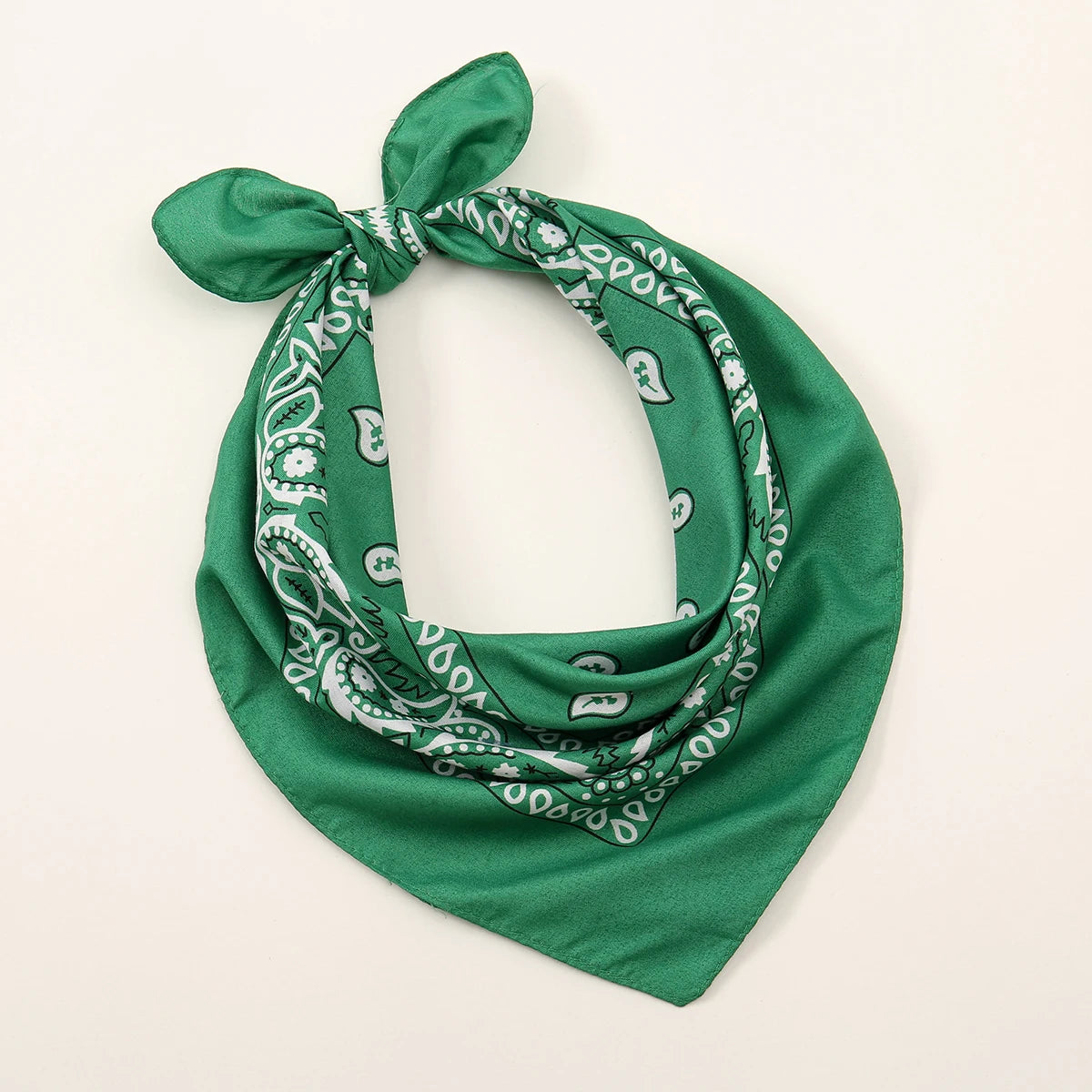 Foulard en coton vert foncé à motif paisley, noué en nœud.