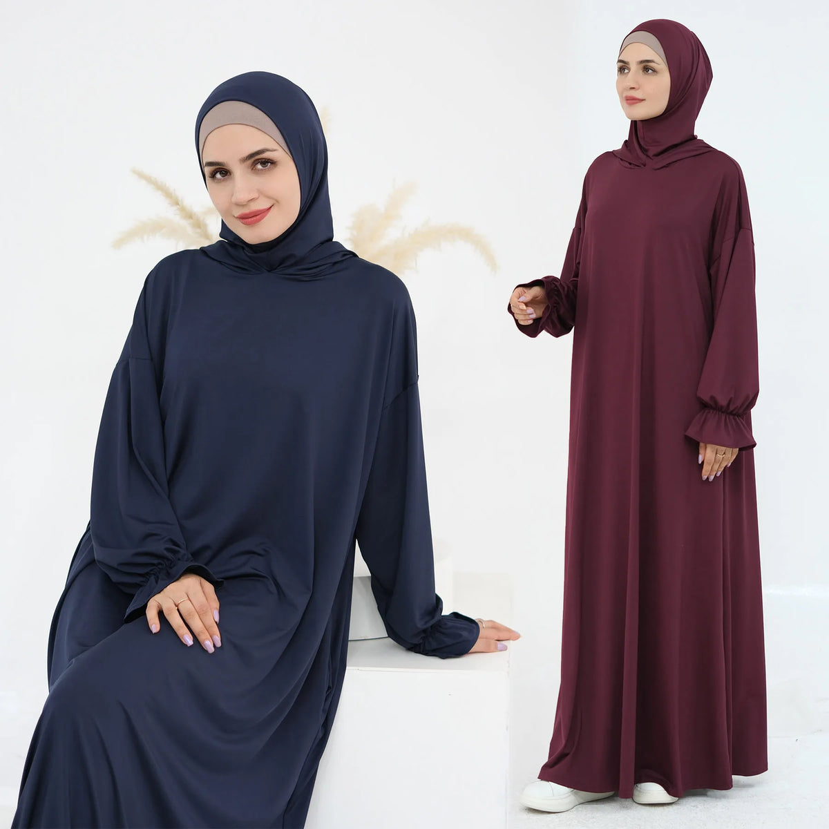 Una mujer vistiendo un vestido abaya suelto y fluído de color azul marino oscuro para la oración.