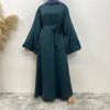 Una elegante abaya de encaje color verde azulado oscuro, con mangas largas y cintura atada.