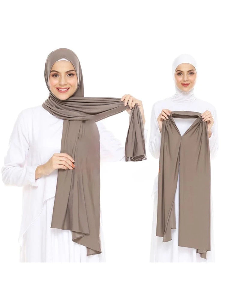 Une femme modèle un foulard instant en jersey beige et extensible drapé sur sa tête et ses épaules.