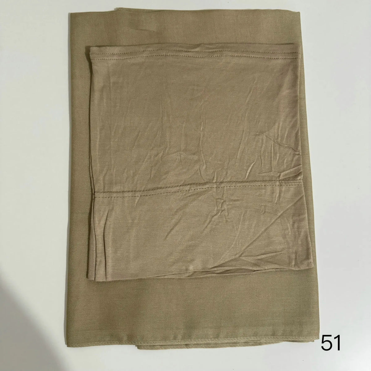 A solid olive green soft modal rayon hijab set folded flat.