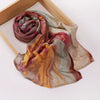 Voile hijab imprimé drapé dans les tons rose poudré, beige et or, présenté sur un cadre en bois.