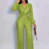 A woman models a lime green ribbed knit jumpsuit with puff sleeves against a light gray background.