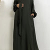 Lange dunkelolivgrüne marokkanische Kaftan-Abaya, getragen von einer Frau.