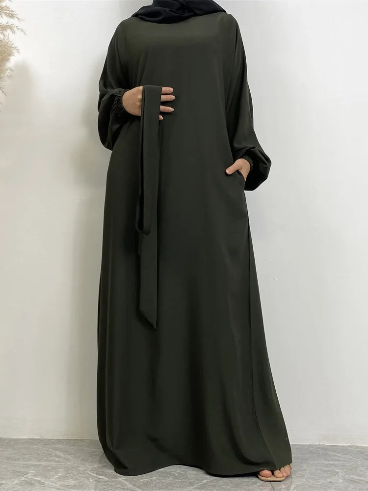 Lange dunkelolivgrüne marokkanische Kaftan-Abaya, getragen von einer Frau.