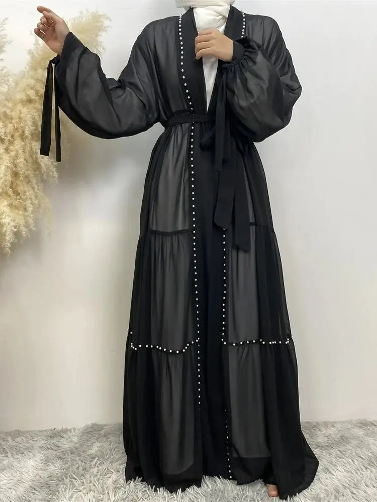 Cardigan abaya negra elegante de manga larga y cintura atada, sobre fondo blanco.