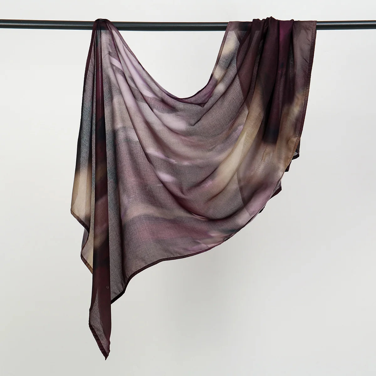 Durchsichtiger lila und brauner Aquarell-Hijab-Schal, über einer Wäscheleine drapiert.