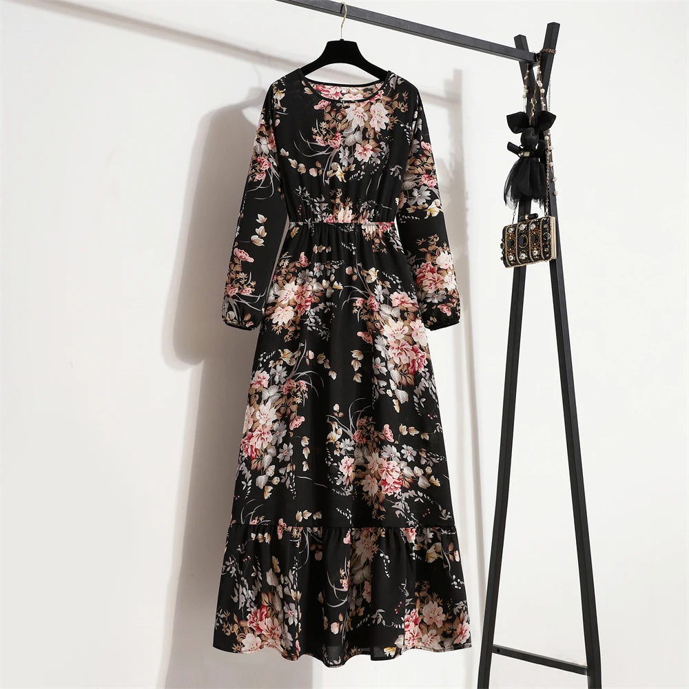 Ein schwarzes Maxi-Kleid mit Blumenmuster hängt an einem schwarzen Kleiderständer.