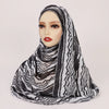 Una mujer usando un pañuelo hijab con estampado de acuarela bohemio a rayas blanco y negro.