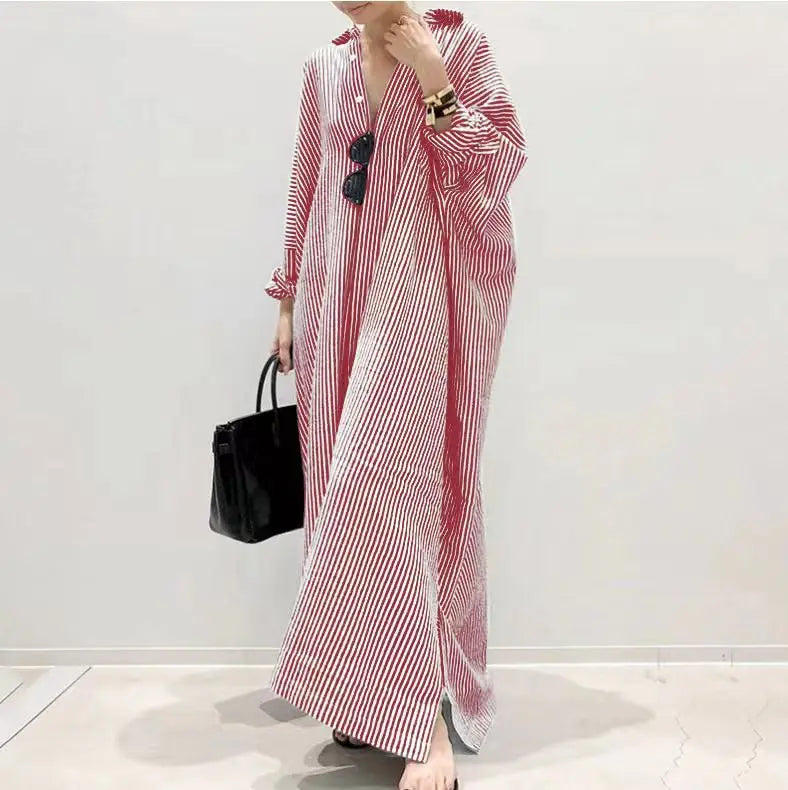Eine Frau trägt ein langes, fließendes rot-weiß gestreiftes Baumwollmaxikleid.