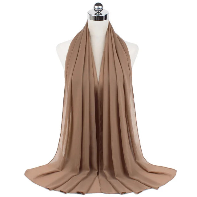 A beige chiffon hijab scarf draped around a mannequin neck.