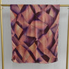 Quadratischer Schal mit geometrischem Muster in Violett- und Rosatönen auf hellem Stoff.