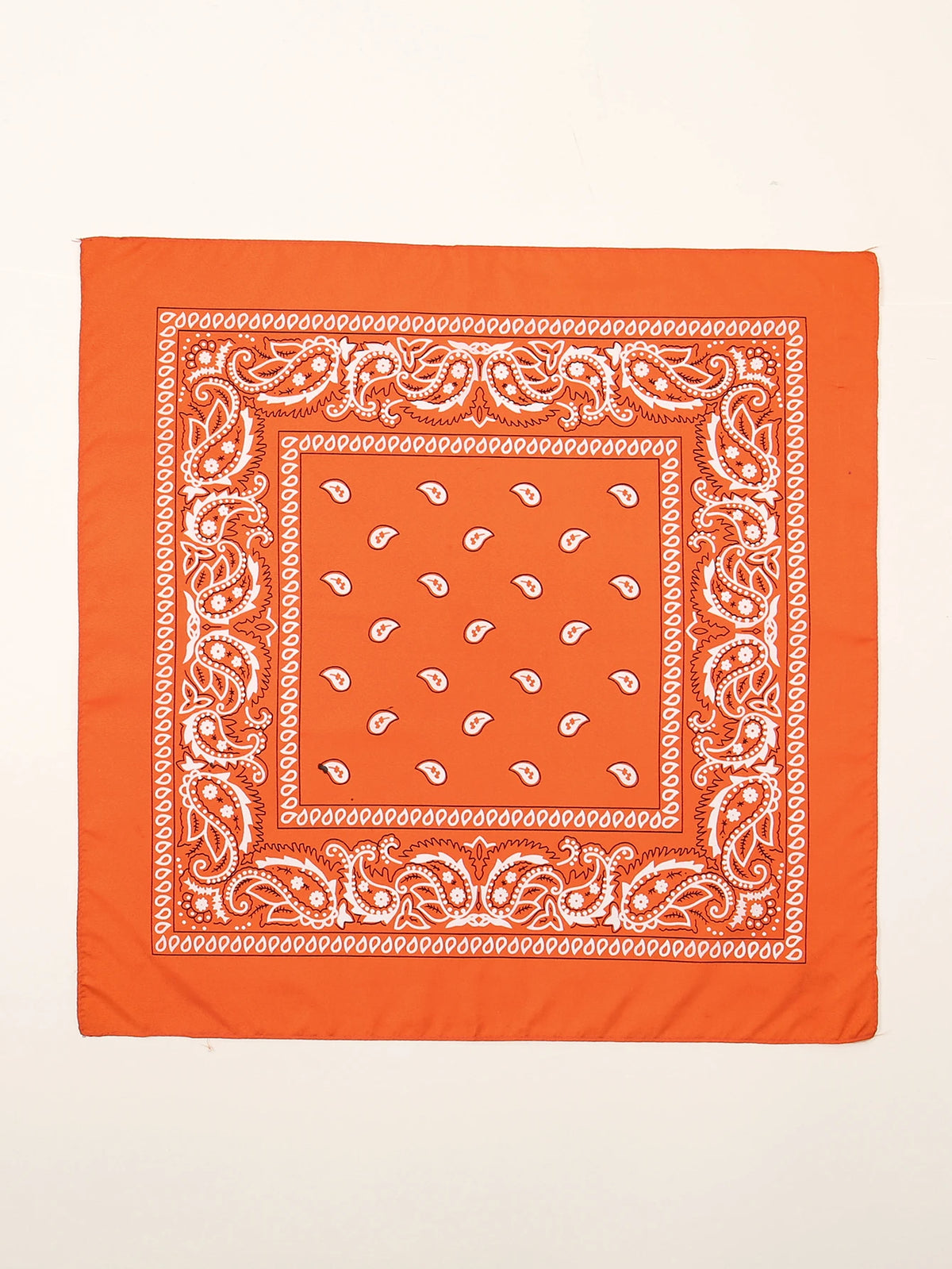 Foulard en coton orange orné de motifs paisley blancs et géométriques complexes.