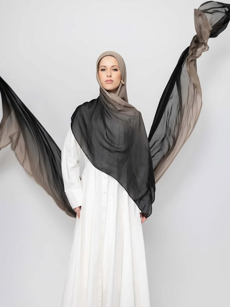 Eine Frau trägt einen schwarzen Ramanda Bamboo Modal Rayon Schal-Hijab über einem weißen Kleid.