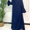 Une abaya en dentelle bleu foncé pour femmes, présentée sur un cintre sur fond blanc.