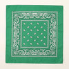 Tissu vert carré avec broderies blanches et motif central de petites formes blanches.