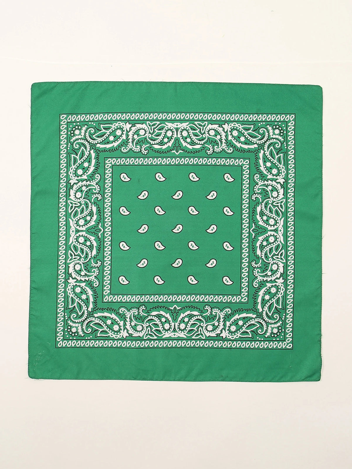 Tissu vert carré avec broderies blanches et motif central de petites formes blanches.