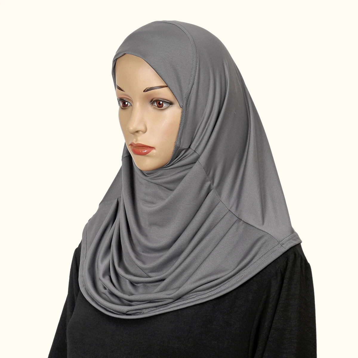 Eine Frau trägt einen einfarbigen grauen, sofort fertigen Hijab und blickt in die Kamera.