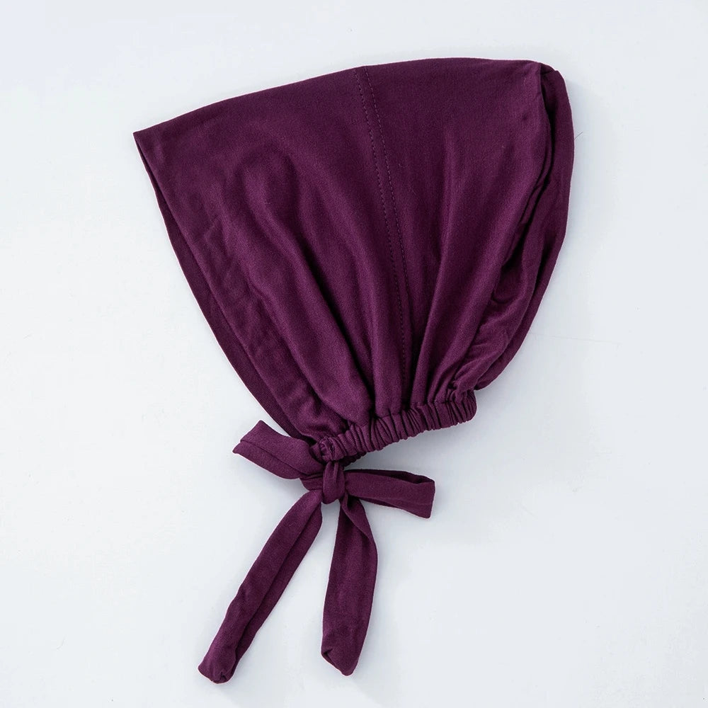 Tiefviolettes, mehrfarbiges Tuch als inneres Hijab-Bonnet, gefaltet und gebunden