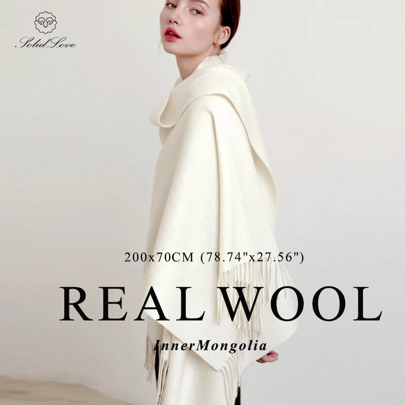 Eine Frau modelliert einen cremefarbenen Wollschal über ihren Schultern.