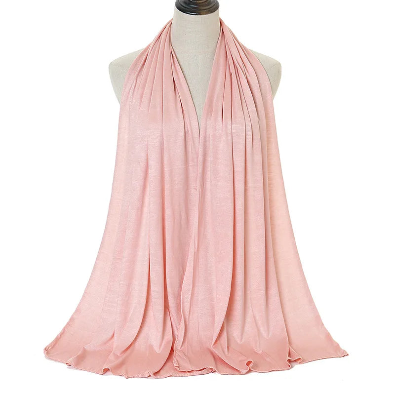A soft pink modal jersey hijab scarf draped around a mannequin's neck.