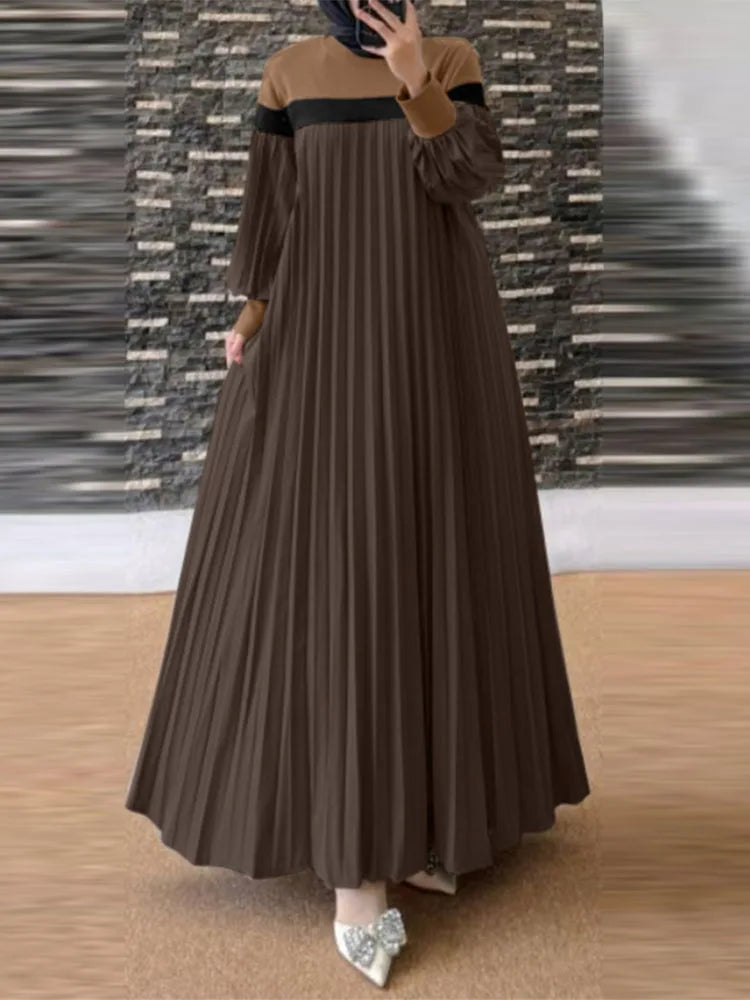 Un mannequin portant une longue caftan plissé marron avec un haut beige et des bordures noires.