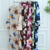 Präsentation von luxuriösen floral gemusterten Abayas für Damen, die an einem Kleiderständer hängen.