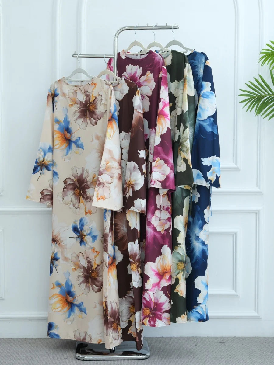Präsentation von luxuriösen floral gemusterten Abayas für Damen, die an einem Kleiderständer hängen.
