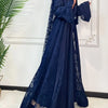Une femme portant un ensemble abaya en dentelle bleu foncé pour l'Aïd du Ramadan, à manches longues et tissu fluide.