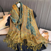 Una pashmina de lujo verde oliva y dorado con patrón, drapeada alrededor del cuello de una persona.