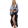 Eine Frau modelliert ein schwarz-weiß gestreiftes Sommer-Strandkimono-Überkleid.