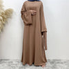 Una abaya color topo, de largo completo y fluido para mujeres, con mangas largas y escote drapeado.