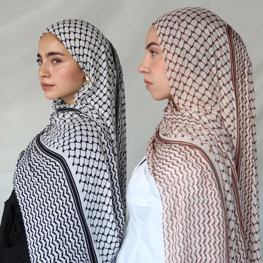 Une femme portant un hijab élégant à motifs marron et blanc et un haut blanc.