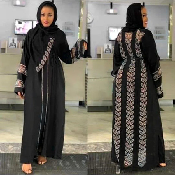 A woman wearing an elegant black abaya with intricate embroidery and a black hijab.