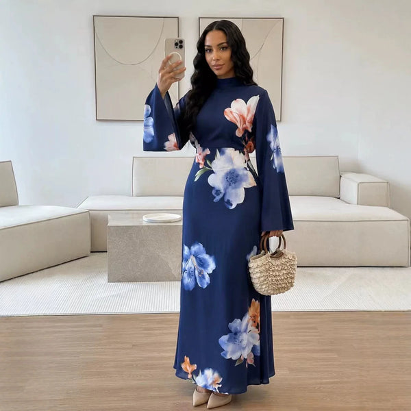 A woman models a navy blue abaya dress with floral embroidery in a bright room.