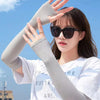 A woman wearing light gray cooling UV protection arm sleeves against a blue sky background.