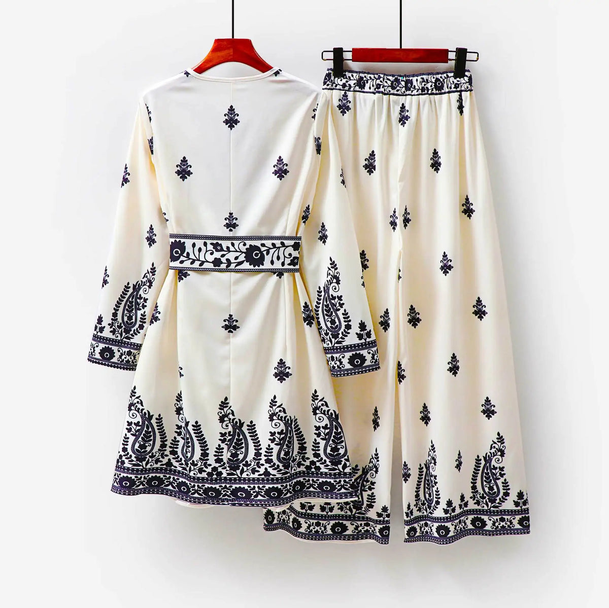 Un conjunto de dos piezas étnico musulmán blanco para mujer con intrincados bordados azul marino y tela estampada.