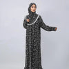 A woman wearing an elegant black and white patterned Muslim hijab dress for prayer and daily wear.