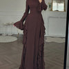 A full-length, dark brown elegant maxi dress with a high neckline and three-quarter sleeves displayed indoors.