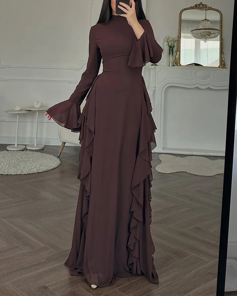 A full-length, dark brown elegant maxi dress with a high neckline and three-quarter sleeves displayed indoors.