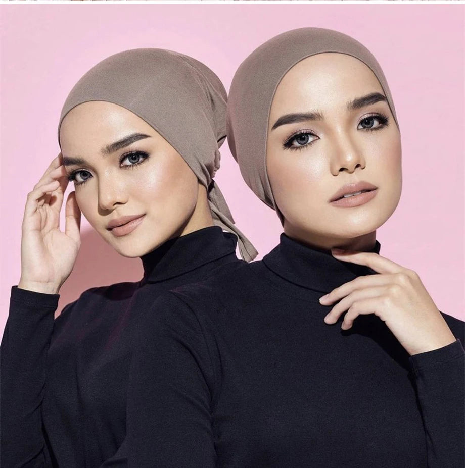 Una mujer vistiendo un elegante turbante de hijab modal beige y una blusa de cuello alto negra.