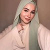 A woman wearing a light green chiffon matching inner scarf set with a pale pink top.