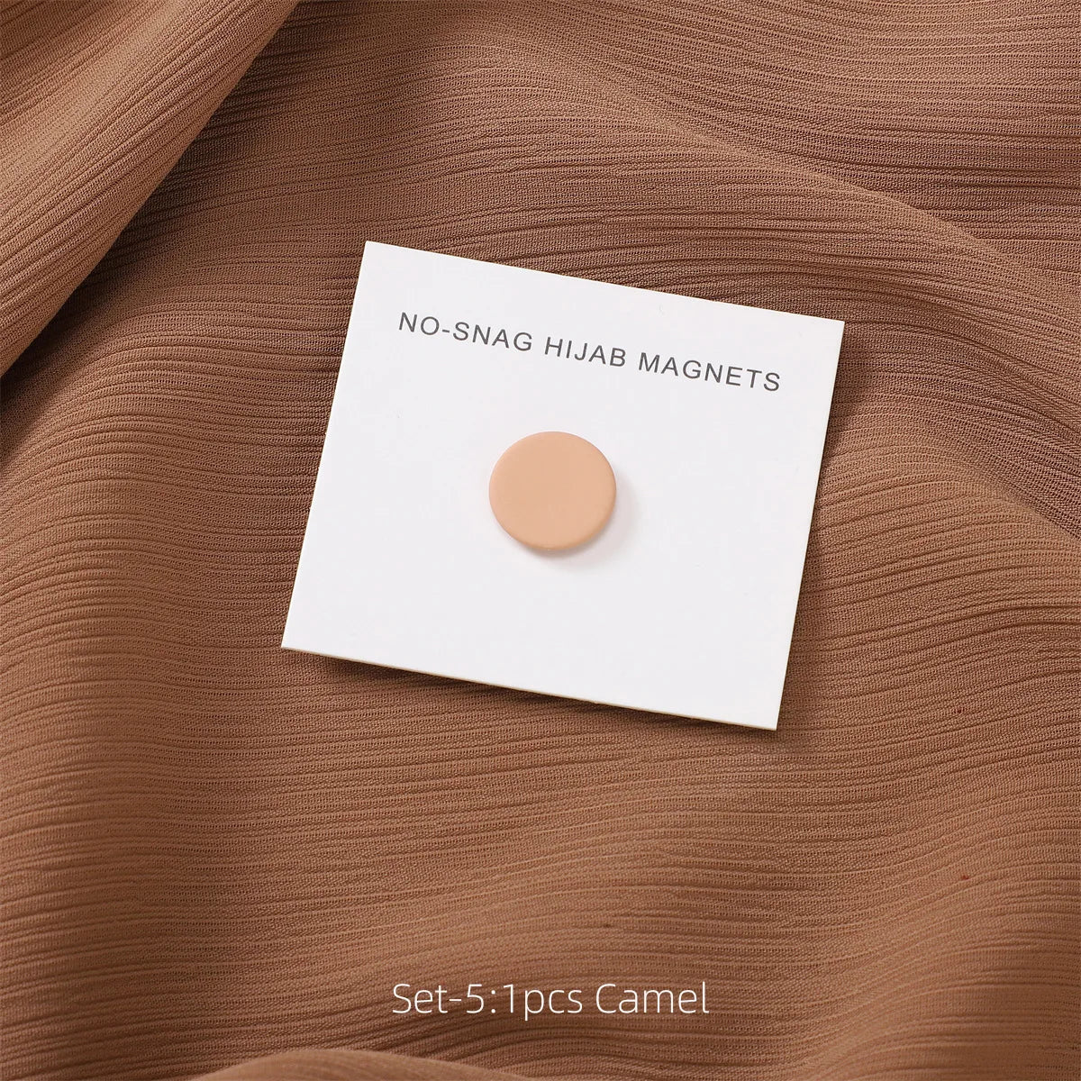 Juego de cinco imanes de hijab de color camello, mostrados sobre tela marrón.