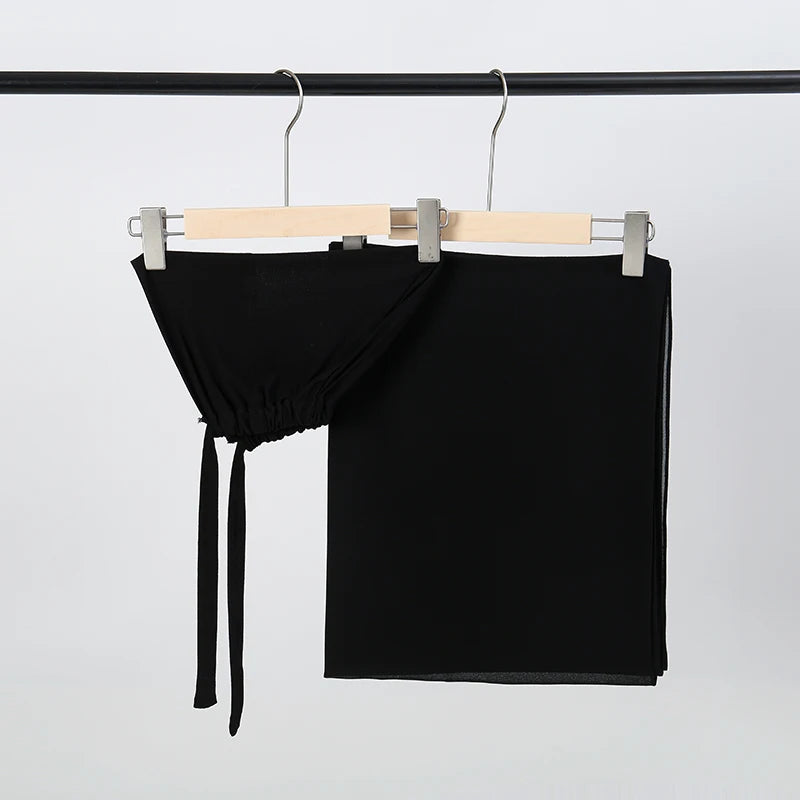 Schwarzer Chiffon-Hijab und Untercap-Set an einem Holzhaken