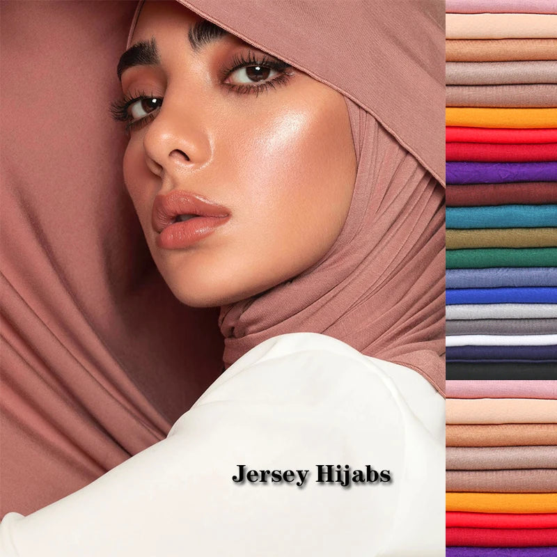 Close-up of a woman wearing a dusty rose jersey hijab with a white sleeve, displayed next to stacked fabric colors.