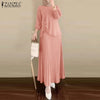 Une femme modélise un ensemble tunique et jupe longue plissée rose.