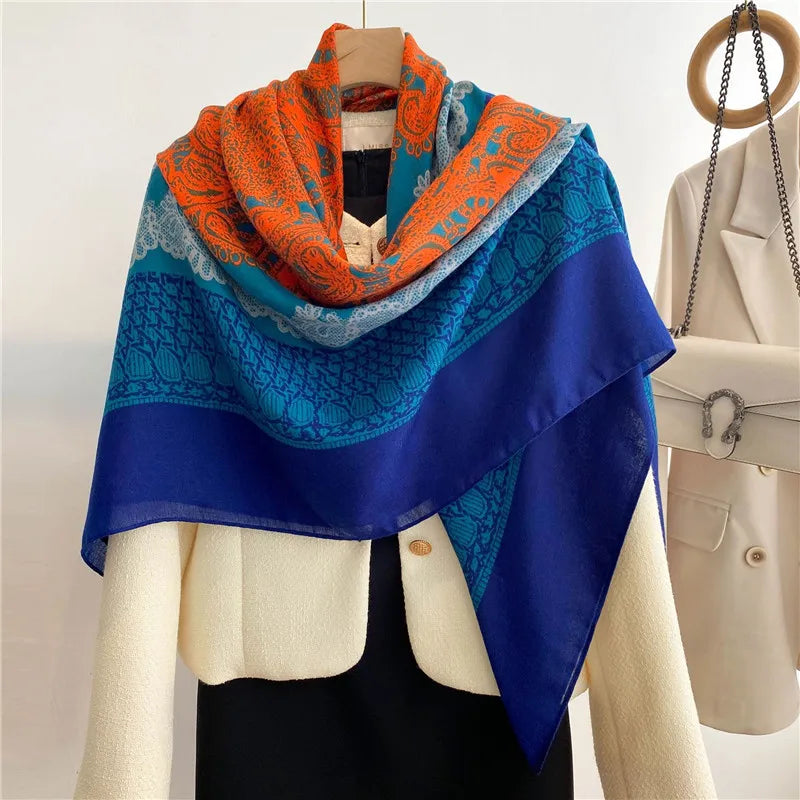 Lebendiges blaues Viskose-Schal mit orangefarbener Blumenverzierung, drapiert über einem Mannequin.