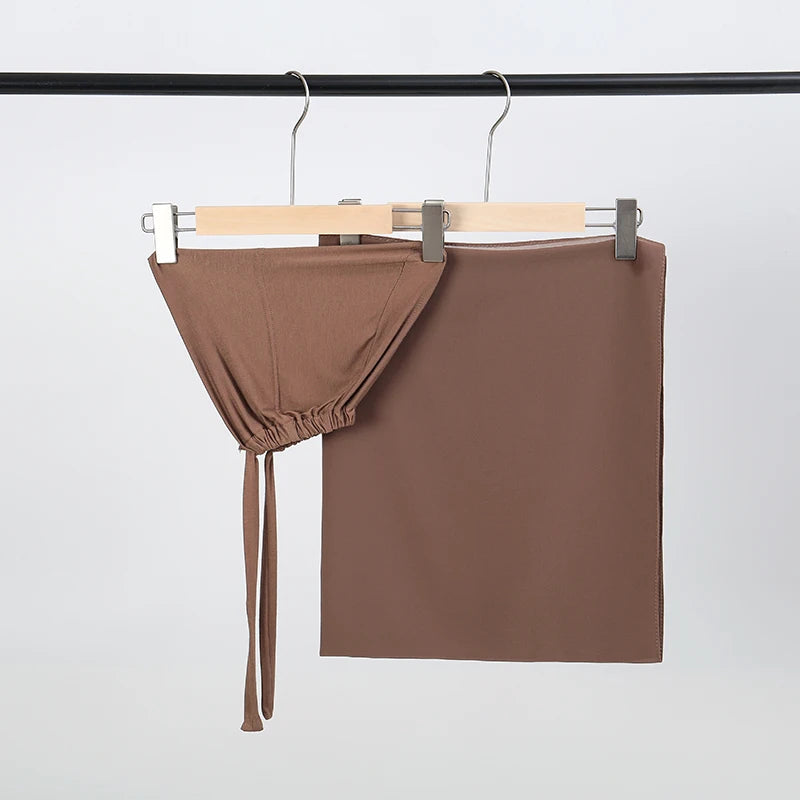 Braunes Chiffon-Hijab und Untercap-Set an einem schwarzen Stäbchen aufgehängt.